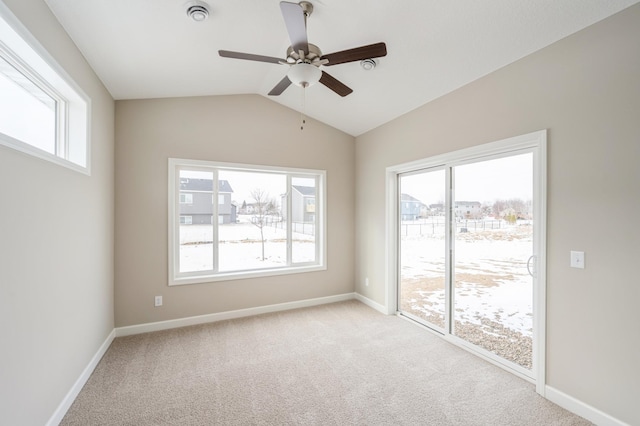 carpeted spare room with lofted ceiling, a wealth of natural light, and ceiling fan