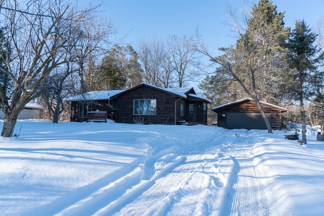 view of front of home with a carport, a garage, and an outbuilding