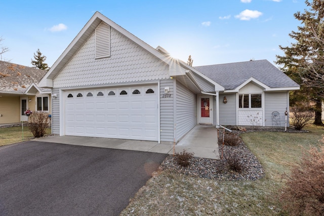 ranch-style home with a garage and a front lawn