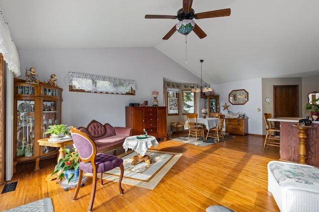 living room featuring lofted ceiling, hardwood / wood-style floors, and ceiling fan