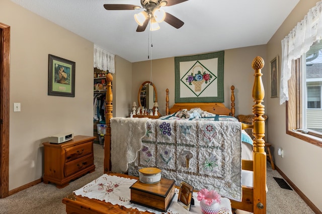 carpeted bedroom featuring ceiling fan, a spacious closet, and a closet