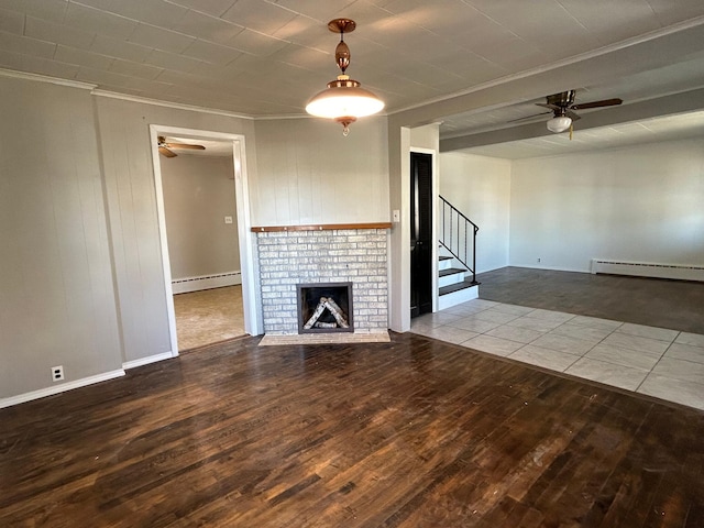 unfurnished living room with crown molding, wood-type flooring, a fireplace, and a baseboard heating unit