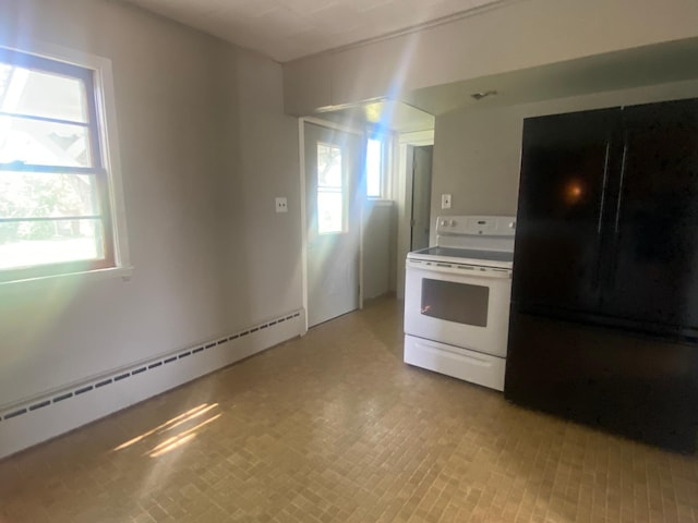 kitchen featuring a baseboard radiator, black fridge, plenty of natural light, and electric stove