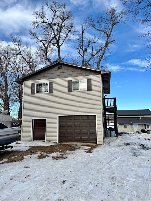 snow covered property with a garage