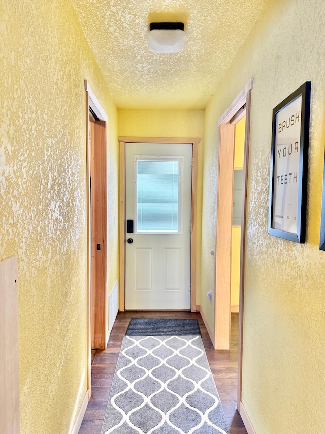 hallway with wood-type flooring and a textured ceiling