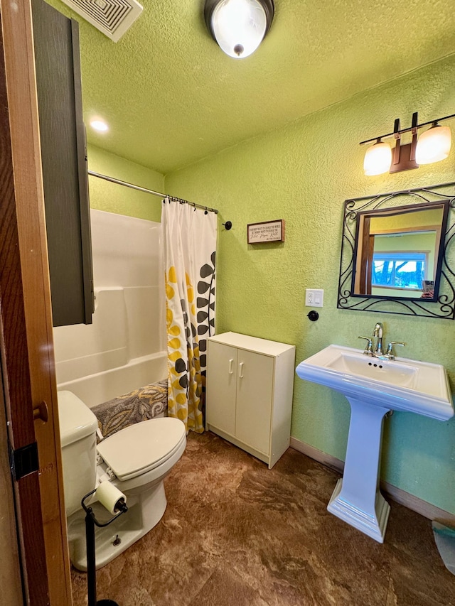 full bathroom featuring toilet, sink, a textured ceiling, and shower / bath combo with shower curtain