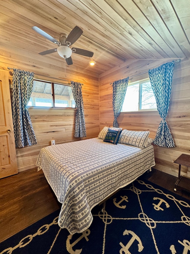 bedroom with dark hardwood / wood-style flooring, wood ceiling, wooden walls, and ceiling fan