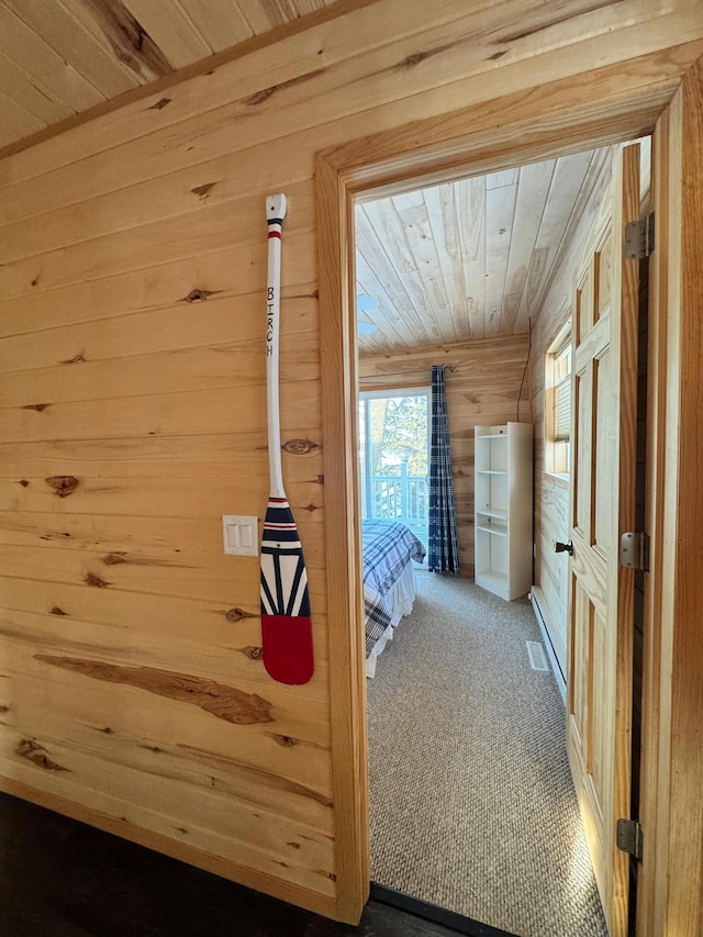 interior space with wood ceiling, carpet, and wood walls