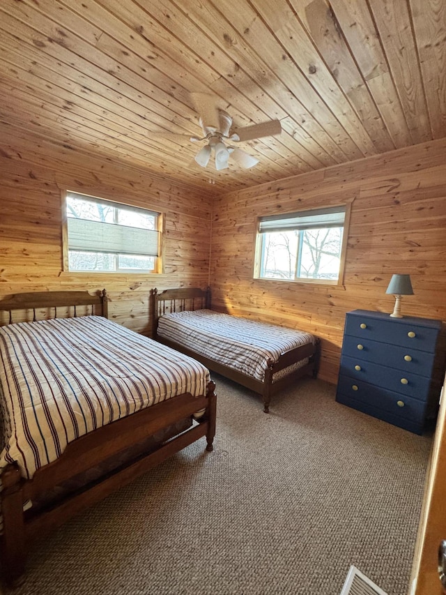 unfurnished bedroom featuring ceiling fan, carpet flooring, wood ceiling, and wood walls