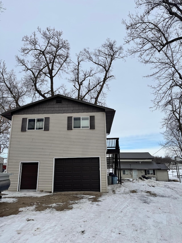 view of snow covered exterior with a garage