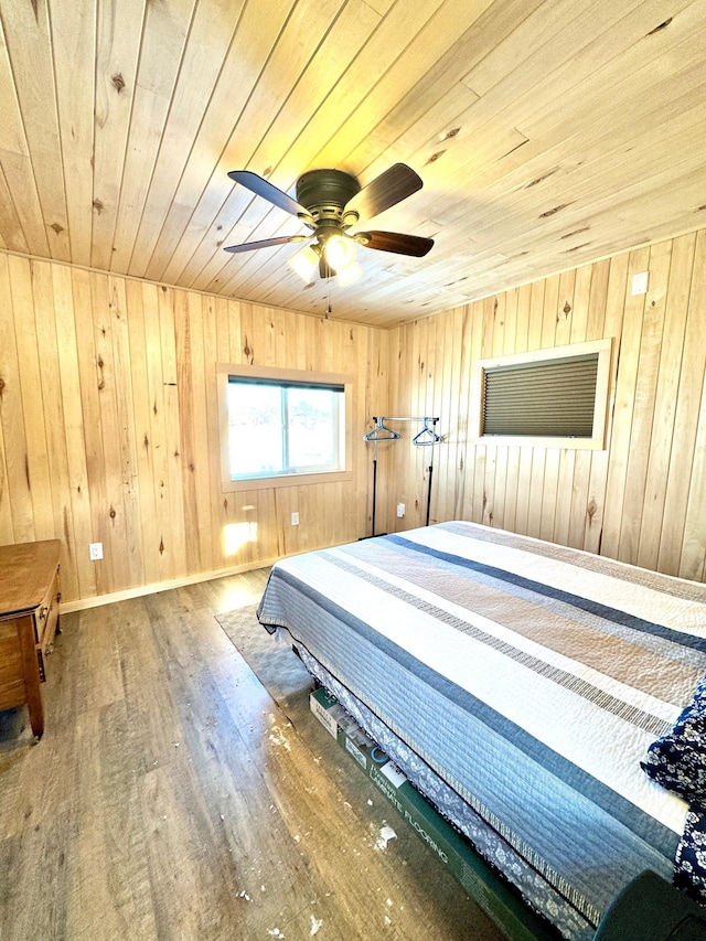 bedroom with hardwood / wood-style floors, wooden ceiling, ceiling fan, and wood walls