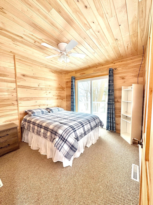 carpeted bedroom featuring wooden walls, wooden ceiling, ceiling fan, and access to outside