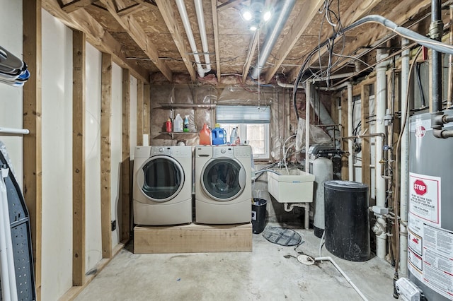 below grade area with gas water heater, washing machine and dryer, and a sink