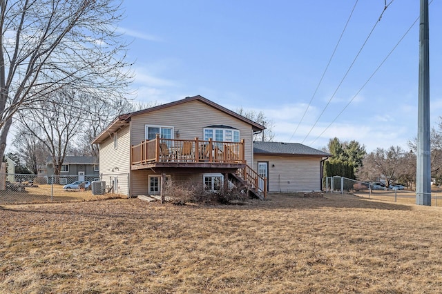 back of property with cooling unit, fence, a lawn, and a wooden deck