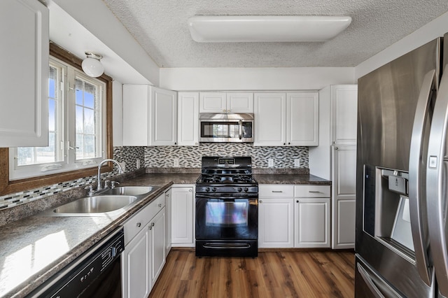 kitchen featuring dark wood finished floors, a sink, black appliances, white cabinetry, and backsplash