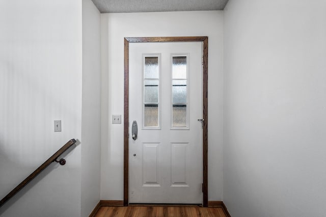 doorway to outside with baseboards and dark wood-style flooring