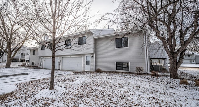 raised ranch featuring a garage and central air condition unit