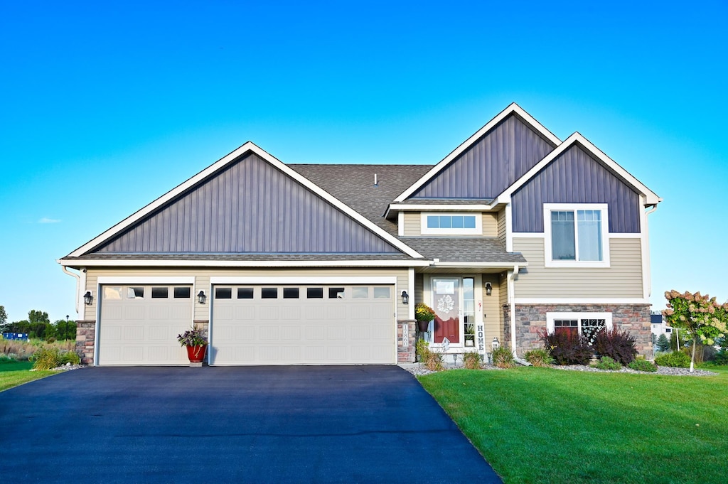 craftsman house with a garage and a front lawn