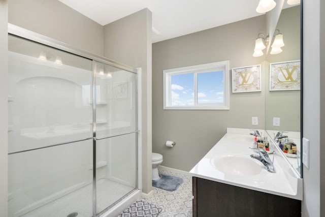 bathroom with a chandelier, vanity, toilet, and a shower with shower door