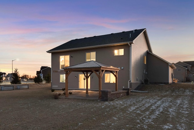 back house at dusk featuring a gazebo, central AC, and a patio