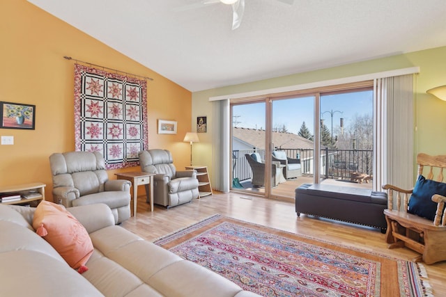 living room with light hardwood / wood-style flooring, vaulted ceiling, and ceiling fan