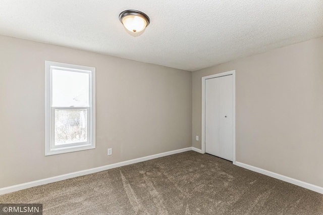 carpeted spare room with a textured ceiling