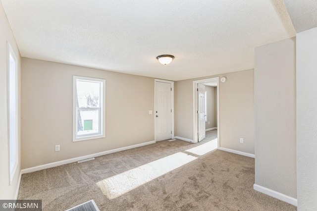 carpeted spare room with a textured ceiling