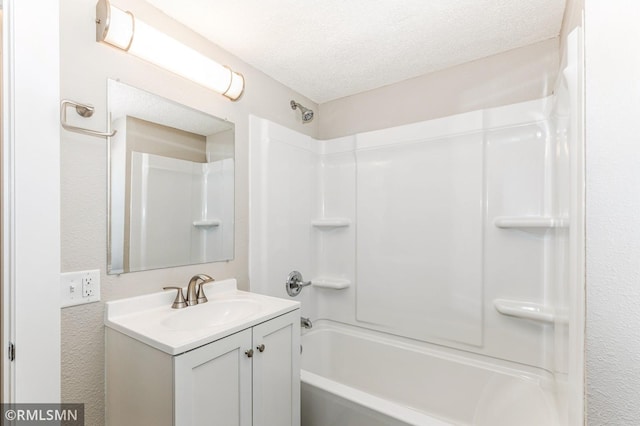 bathroom with vanity, shower / bathtub combination, and a textured ceiling