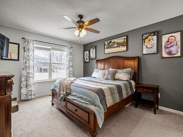 bedroom featuring ceiling fan, light colored carpet, and a textured ceiling