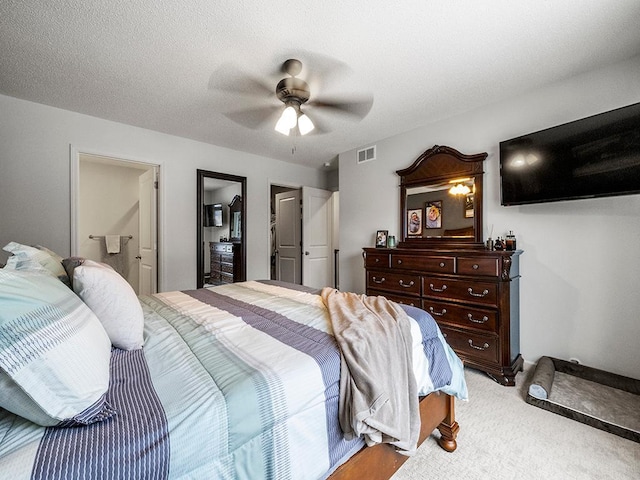 carpeted bedroom featuring ceiling fan and a textured ceiling