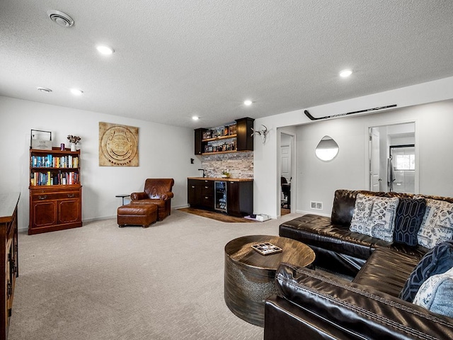 living room featuring light carpet, bar area, and a textured ceiling