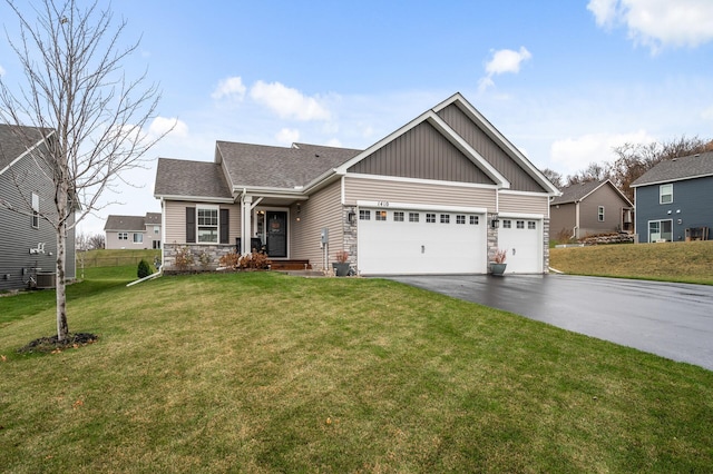 craftsman-style home featuring an attached garage, stone siding, a front yard, and driveway