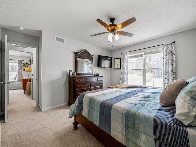 bedroom featuring a textured ceiling, light colored carpet, a ceiling fan, baseboards, and visible vents