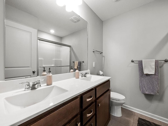 full bathroom with double vanity, a sink, toilet, and a shower stall