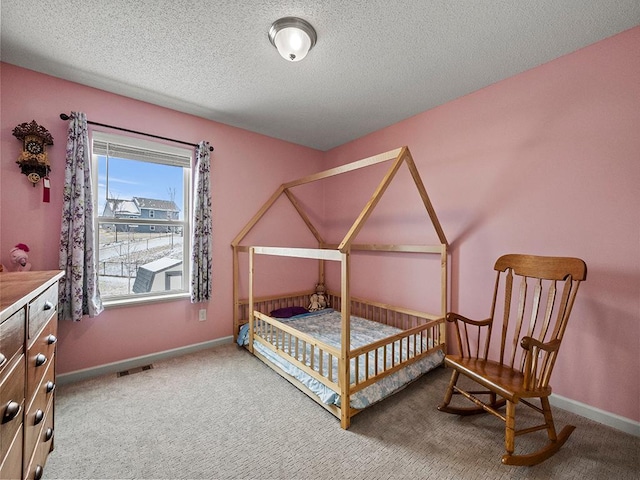 bedroom featuring visible vents, a textured ceiling, baseboards, and carpet flooring