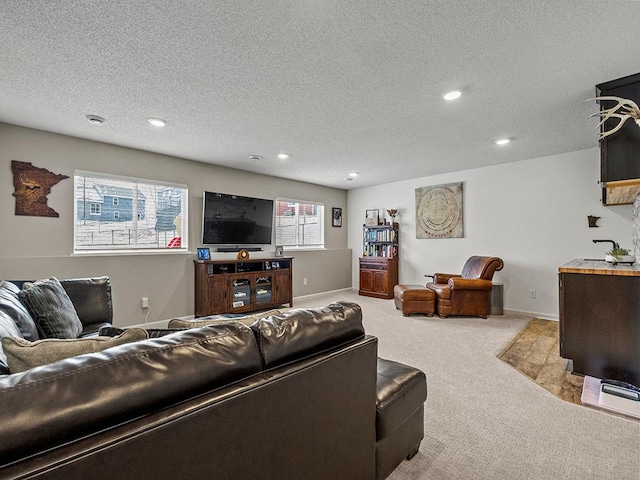 living area featuring recessed lighting, light carpet, and a textured ceiling