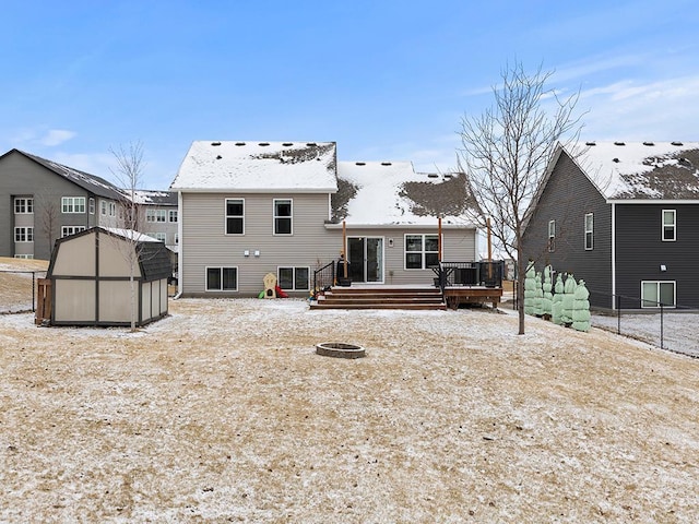 rear view of house featuring a shed, a deck, and an outbuilding