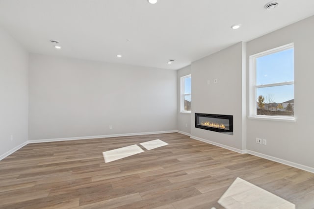 unfurnished living room featuring light hardwood / wood-style flooring and a wealth of natural light