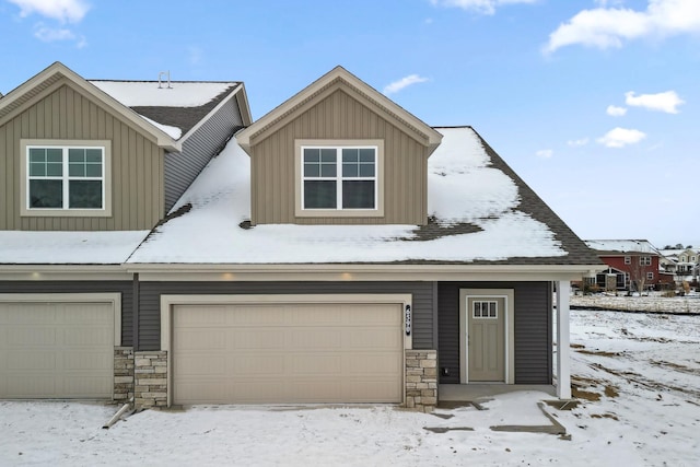 view of front of house with stone siding, board and batten siding, and an attached garage