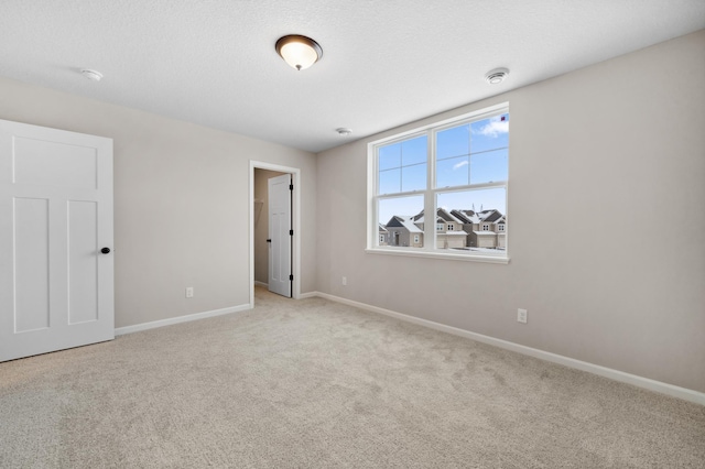 carpeted empty room featuring a textured ceiling