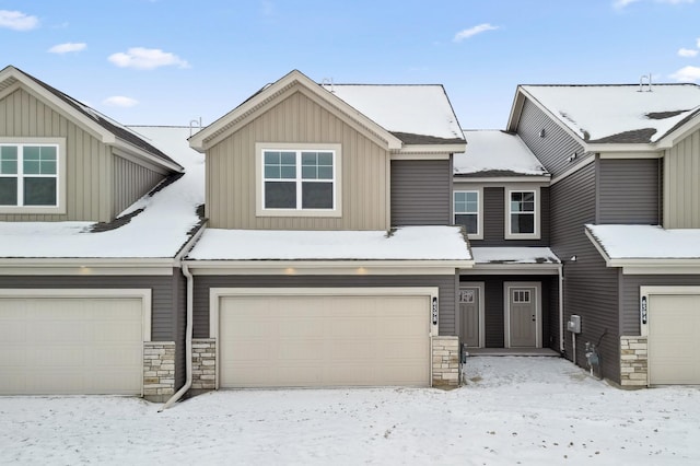 multi unit property featuring an attached garage and board and batten siding