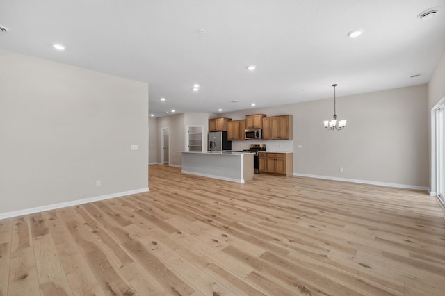 unfurnished living room featuring light wood-style floors, recessed lighting, a notable chandelier, and baseboards