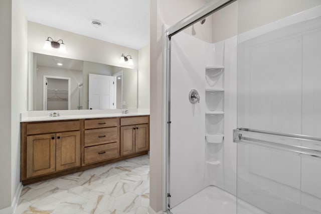 bathroom with marble finish floor, double vanity, a sink, and a shower stall