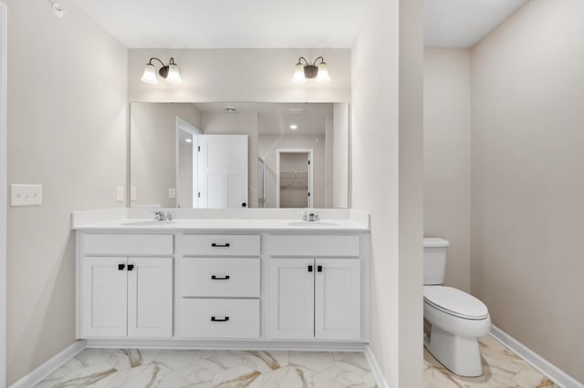 bathroom featuring marble finish floor, a sink, and baseboards