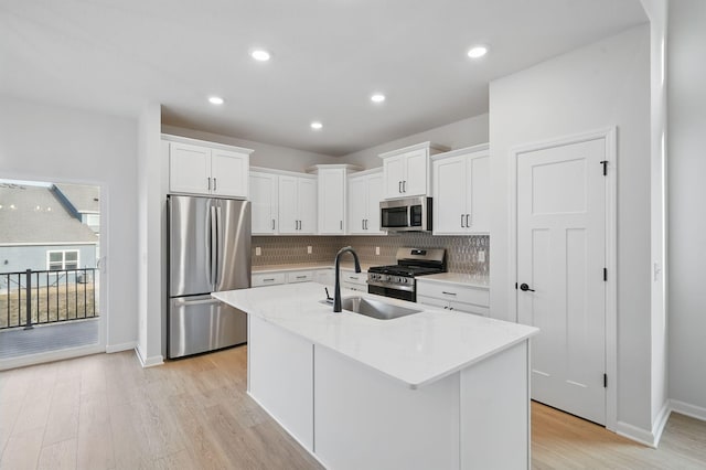6566 Jody Ave S, Cottage Grove, MN 55016 - kitchen with appliances with stainless steel finishes, a sink, light wood-style flooring, baseboards, and tasteful backsplash