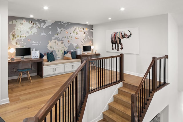 stairway with recessed lighting, wallpapered walls, baseboards, and wood finished floors