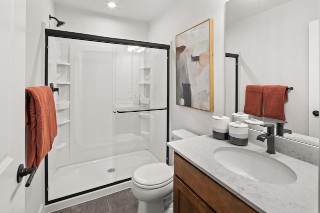 bathroom with vanity, a shower stall, and toilet