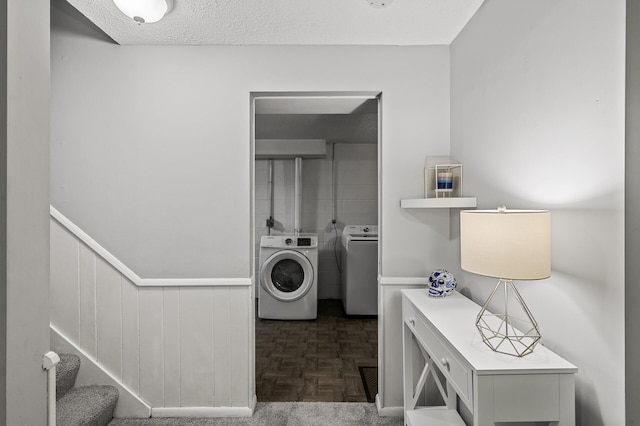 washroom featuring washing machine and dryer, dark parquet floors, and a textured ceiling