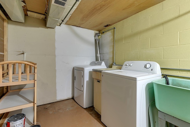 clothes washing area featuring independent washer and dryer and sink