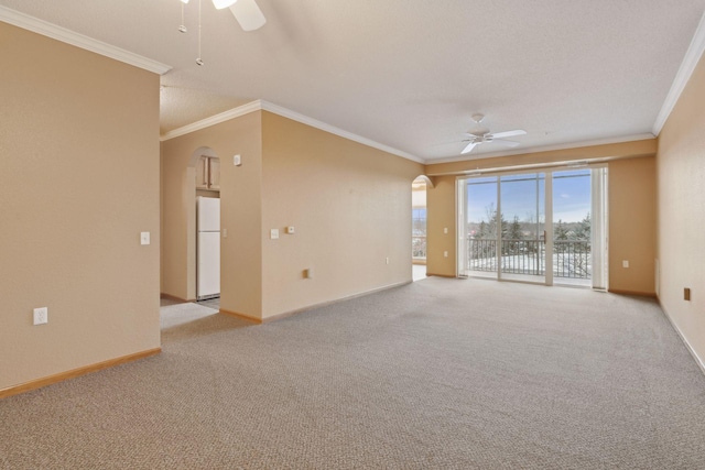 empty room featuring light carpet, crown molding, and ceiling fan